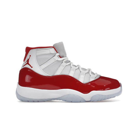 Jordan 11 Retro Cherry (2022) - Image 1 - Only at www.BallersClubKickz.com - The Air Jordan 11 Cherry features classic patent leather with Cherry red accents, icy blue outsole, and debossed 23 on the heel tab. Refresh your sneaker game with this iconic update, available December 10, 2022.