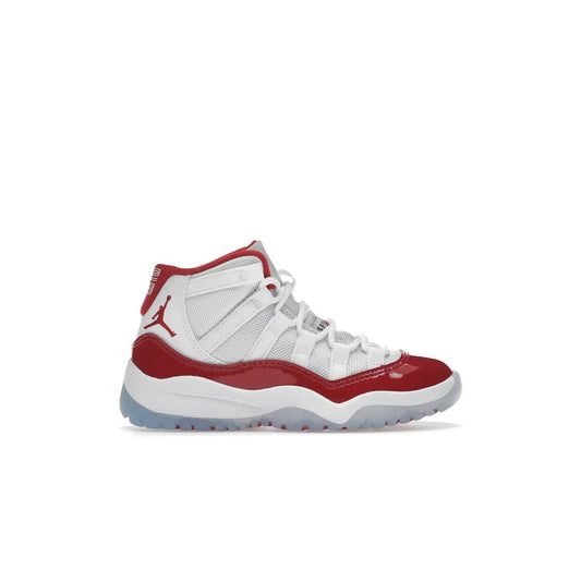 Jordan 11 Retro Cherry (2022) (PS) - Image 1 - Only at www.BallersClubKickz.com - An iconic silhouette with a timeless look, the Air Jordan 11 Retro Cherry 2022 PS features a crisp White, Varsity Red and Black colorway. The upper is made of ballistic mesh, a red patent leather mudguard, '23' branding and white Phylon midsole. Get optimal cushioning and comfort on December 10th, 2022. Don't miss out.