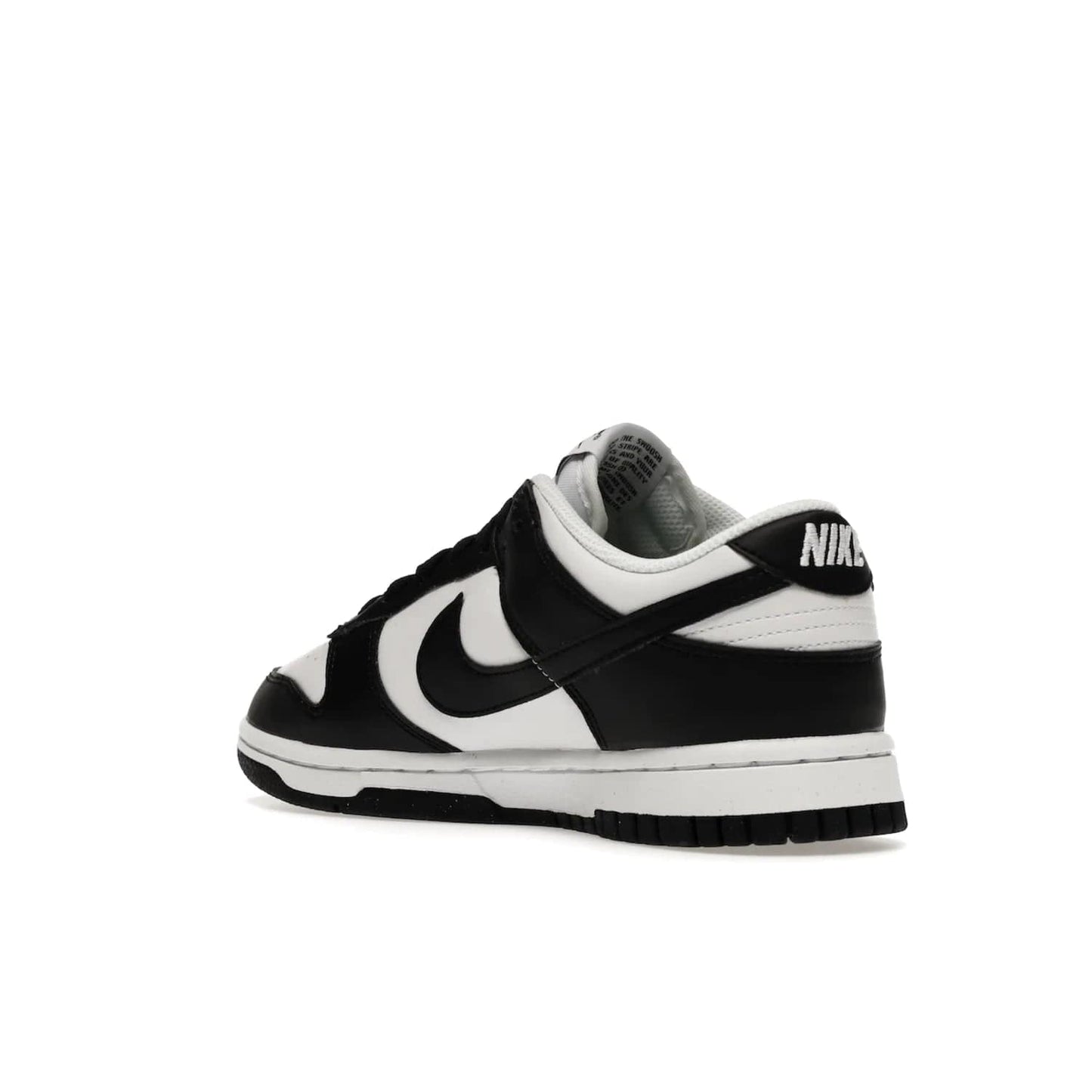 Nike Dunk Low Next Nature White Black Panda (Women's) - Image 24 - Only at www.BallersClubKickz.com - Experience sustainable fashion with the Women's Nike Dunk Low Next Nature White Black. Made with 50% recycled materials, this shoe offers a two-tone black and white Flyleather upper, matching soles and woven tongue labels. Available in November 2021.