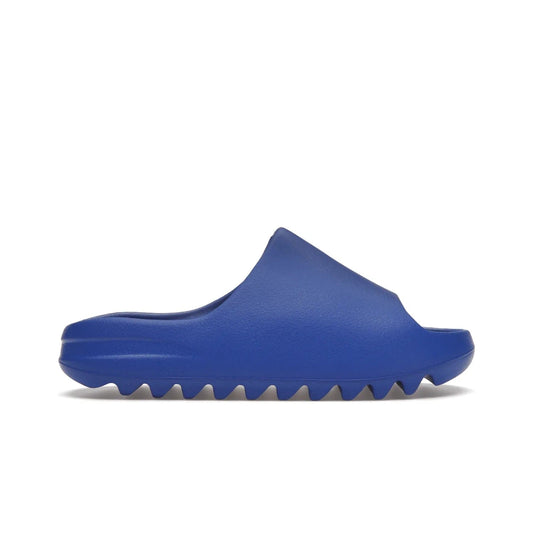 adidas Yeezy Slide Azure - Image 1 - Only at www.BallersClubKickz.com - Elevate your look with the adidas Yeezy Slide Azure. Boasting a vibrant hue for a unique style, this EVA foam slide is a statement of fearlessness and stylish expression. Step out with confidence knowing you're wearing more than a slide.