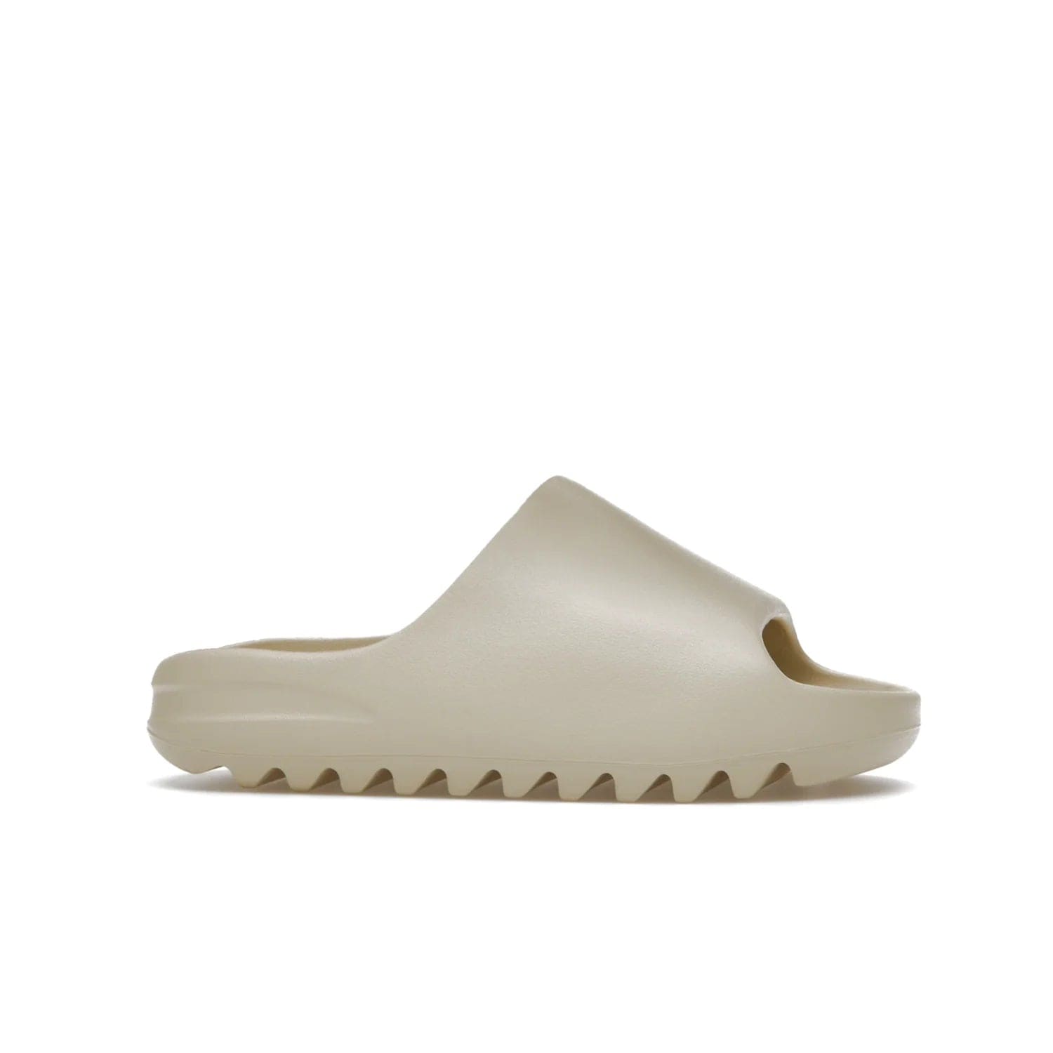 adidas Yeezy Slide Bone (2022 Restock) - Image 2 - Only at www.BallersClubKickz.com - Stay comfy with the adidas Yeezy Slide Bone - a fashionable silhouette with all-day comfort. This Bone/Bone/Bone colorway combines style and comfort with a pebbled texture and grooved sole. Restocked in May 2022, this shoe is the perfect addition to your collection.