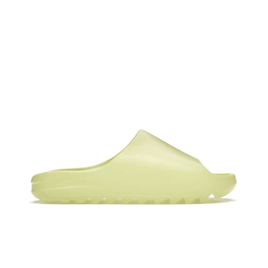 adidas Yeezy Slide Glow Green - Image 1 - Only at www.BallersClubKickz.com - Experience an unexpected summer style with the adidas Yeezy Slide Glow Green. This limited edition slide sandal provides a lightweight and durable construction and a bold Glow Green hue. Strategic grooves enhance traction and provide all-day comfort. Make a statement with the adidas Yeezy Slide Glow Green.