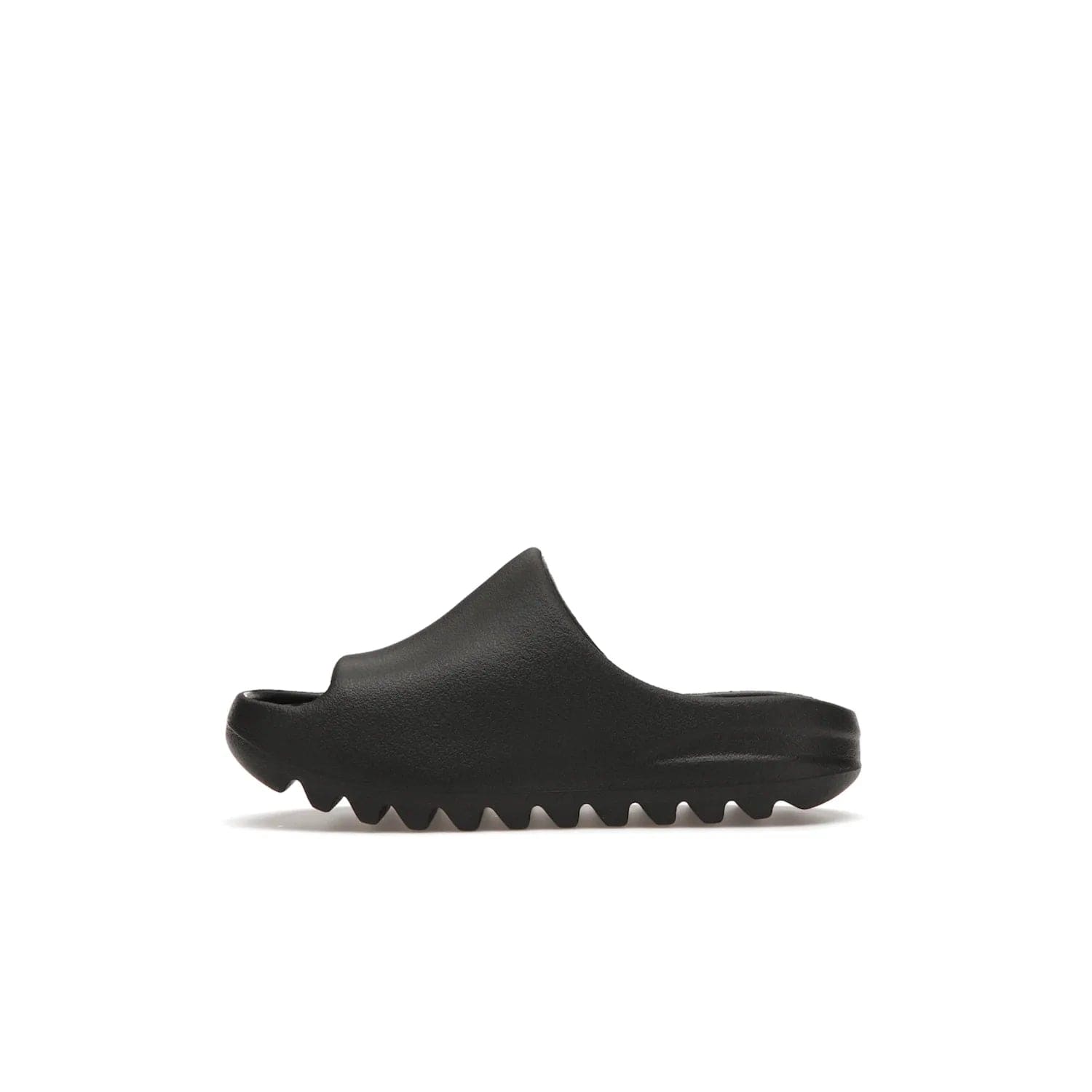 adidas Yeezy Slide Onyx (Kids) - Image 19 - Only at www.BallersClubKickz.com - adidas Yeezy Slide Onyx (Kids): Comfortable foam construction with textured surface and iconic three-stripe logo. Breathable, open-toe design and deep grooves for traction. Released in March 2021 at $50.