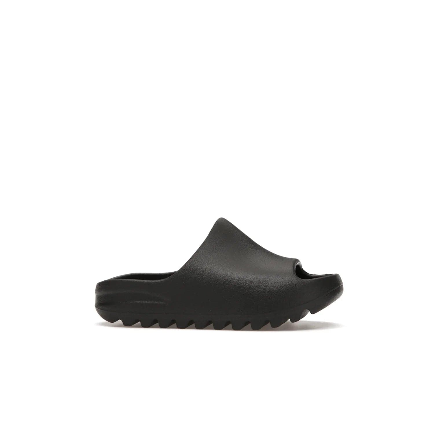 adidas Yeezy Slide Onyx (Kids) - Image 2 - Only at www.BallersClubKickz.com - adidas Yeezy Slide Onyx (Kids): Comfortable foam construction with textured surface and iconic three-stripe logo. Breathable, open-toe design and deep grooves for traction. Released in March 2021 at $50.