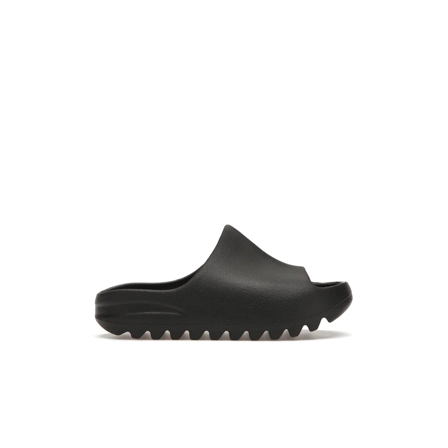 adidas Yeezy Slide Onyx (Kids) - Image 1 - Only at www.BallersClubKickz.com - adidas Yeezy Slide Onyx (Kids): Comfortable foam construction with textured surface and iconic three-stripe logo. Breathable, open-toe design and deep grooves for traction. Released in March 2021 at $50.