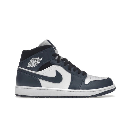 Jordan 1 Mid Armory Navy - Image 1 - Only at www.BallersClubKickz.com - The Jordan 1 Mid Armory Navy: classic basketball sneaker with soft white leather upper, deep navy blue overlays, and black leather ankle detailing. Iconic style with Jordan Wings logo and Jumpman label.