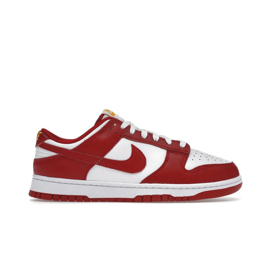 Nike Dunk Low USC - Image 1 - Only at www.BallersClubKickz.com - The Nike Dunk Low USC DD1391-602 colorway captures the eye of University of Southern California fans. Crafted with leather and rubber upper and outsole, this stylish sneaker features a white, gym red, and yellow colorway. With yellow Nike branding, white perforated vamp, and red suede Swoosh, this sneaker turns heads. Get the classic Nike Dunk Low USC releasing on November 9th, 2022.